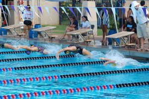 (Photo courtesy of John Adams) Mya Adams (12) (middle), captain of the girls’ swim team, dives into the water to compete individually for varsity championships, leading to the placement of fourth for girls’ swimming.
