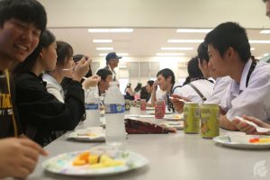 (Matthew Kawamoto | Trojan Times) The students of Miyazaki Kaiyo High School sample local Hawaiian snacks while waiting for performances from both schools to start.